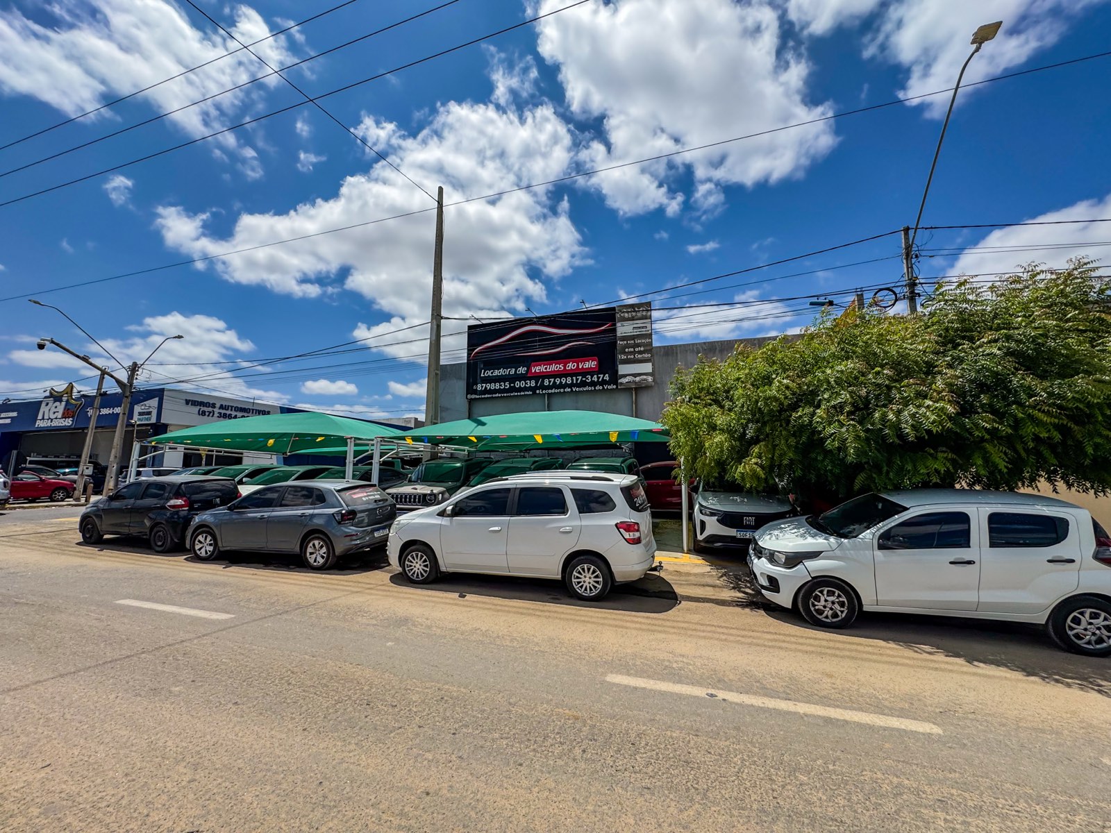 Fachada da Locadora do Vale vista da rua, com o letreiro e carros da frota estacionados